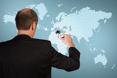 A Businessman is drawing his journey on a world map の写真素材