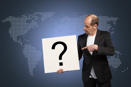 A Businessman is pointing to a white sign with a questionmark 
