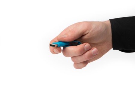 A Hand from a Businessman holds a USB Stick isolated on a white background.の写真素材