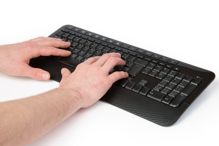 A man is typing with both hands on a black Keyboard.の写真素材