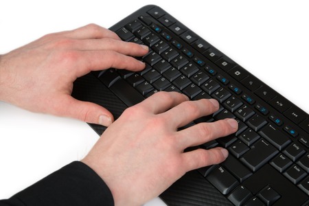 A programmer serves the keyboard to program a tool.の写真素材