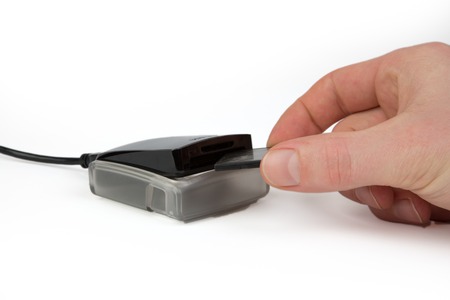 A Business People is putting the card into a reader for data transfer.の写真素材