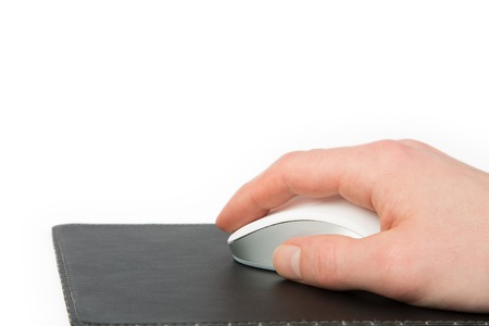 A Businessman is pressing the Button on a white mouse lying on a black mouse pad, isolated on whiteの写真素材