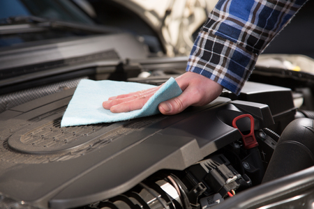 A man is cleaning a car engine block.の写真素材