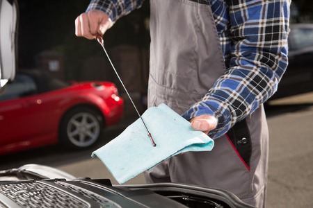 During an inspection a mechanic is checking the oil level.の写真素材