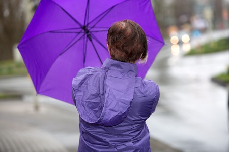 A woman has problems with her umbrella.の写真素材