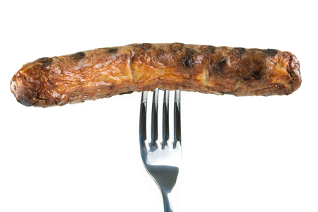 A grilled sausage pierced on a fork, isolated on white with copyspace.の写真素材