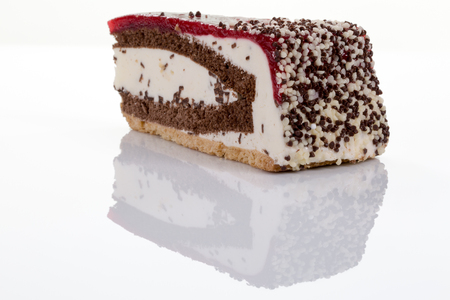 A piece of cherry cream torte isolated on white with reflectionの写真素材