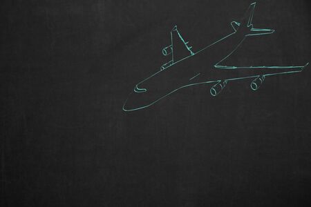 An aircraft drawing with turquoise chalk on a dark chalkboard.の写真素材