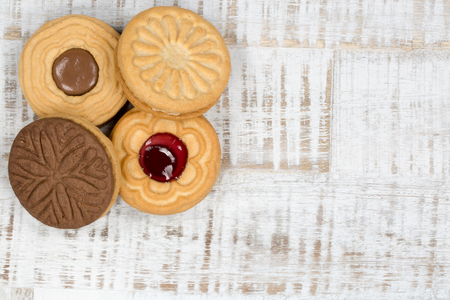 A top view of 4 cookies at the left side on a bright wooden table.の写真素材