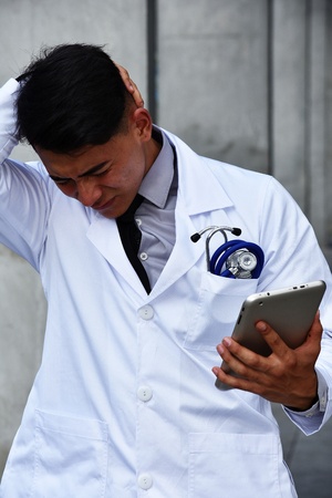 Stressful Male Surgeon Wearing Lab Coatの写真素材