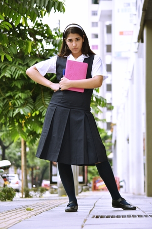Cute Colombian Girl Student Standing Wearing Skirtの写真素材