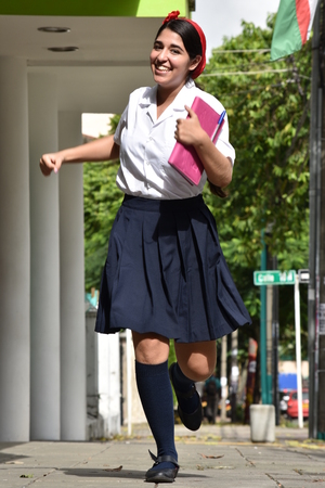 Cute Colombian Girl Student Running With Notebookの写真素材