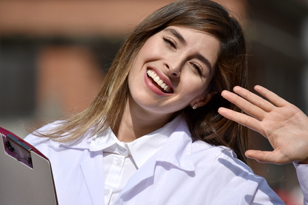 Happy Cute Colombian Female Doctor Wearing Lab Coat With Clipboardの写真素材
