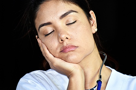 Sleepy Female Nurse Medical Professional Wearing Scrubsの写真素材