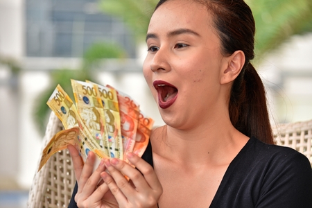 Attractive Filipina Female Counting Moneyの写真素材