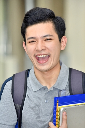 Boy Student Laughing With Booksの写真素材