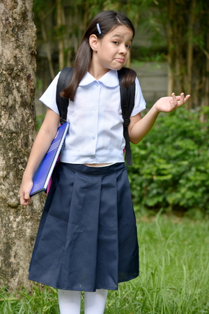 Young Minority Student Child Making A Decision Wearing School Uniform With Booksの写真素材