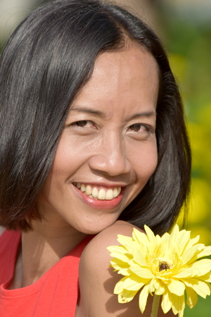 Portrait Of A Youthful Asian Person With A Flowerの写真素材