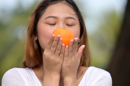 Young Woman Holding An Orangeの写真素材