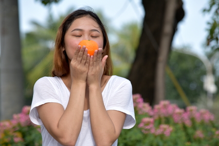 Young Woman Holding An Orangeの写真素材