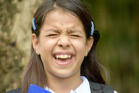 Cute Girl Student Under Stress Wearing Uniform With Booksの写真素材