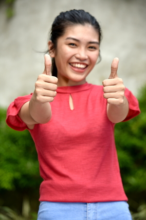 Youthful Asian Teenager Girl With Thumbs Upの写真素材