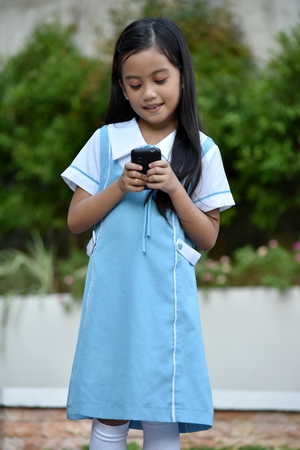 Cute Pretty Filipina Female Student With Smartphoneの写真素材