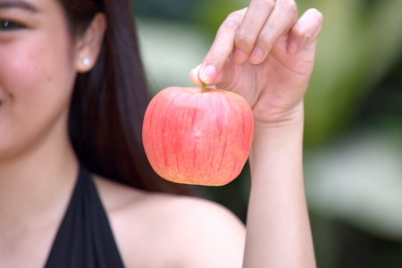 Female Teen Holding An Appleの写真素材