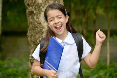 Child Girl Student Laughing Wearing Uniform With Booksの写真素材