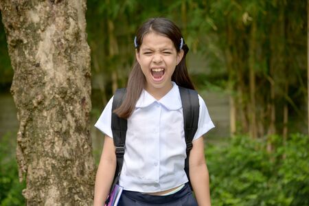 Stressful Asian Child Girl Student Wearing School Uniform With Booksの写真素材