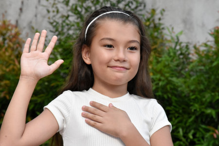 Youthful Philippina Child Pledging Allegiance Outdoorsの写真素材