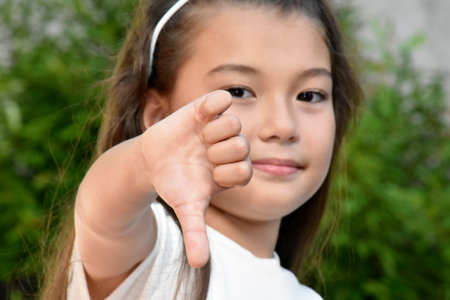 Pretty Philippina Girl With Thumbs Down Outdoorsの写真素材