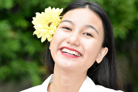 Smiling Youthful Diverse Female With Yellow Flowerの写真素材