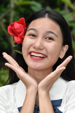 Smiling Beautiful Asian Female With Red Flowerの写真素材