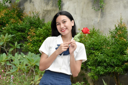 A Happy Asian Woman With Red Flowersの写真素材