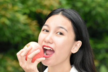 An Asian Woman Eating An Appleの写真素材