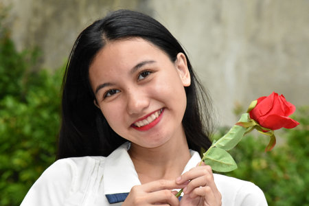 Smiling Beautiful Minority Female With Red Roseの写真素材