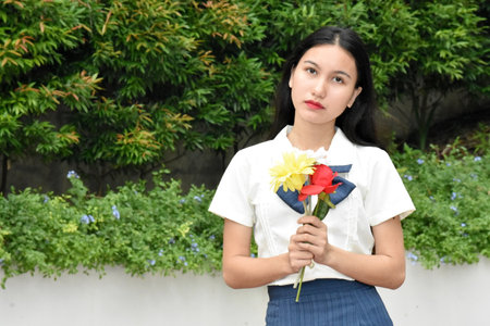 Serious Young Female Woman Wearing School Uniform With Bouquet Of Flowersの写真素材