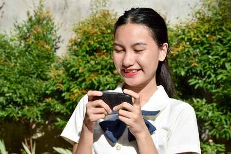 A Happy Teen Female Using Cellphoneの写真素材