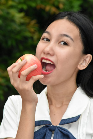Pretty Minority Female Eating An Appleの写真素材