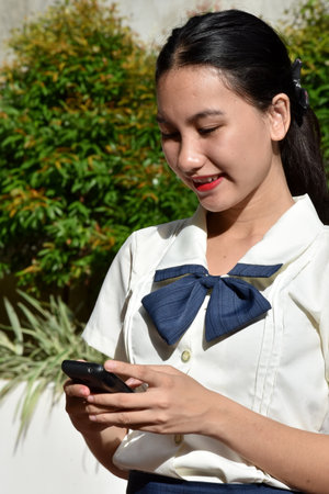 Unemotional Young Minority Adult With Cell Phoneの写真素材