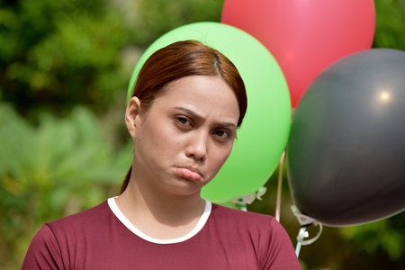 Unhappy Attractive Redhead Person With Balloonsの写真素材