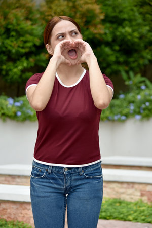Pretty Filipina Adult Female Shouting Wearing Tshirtの写真素材