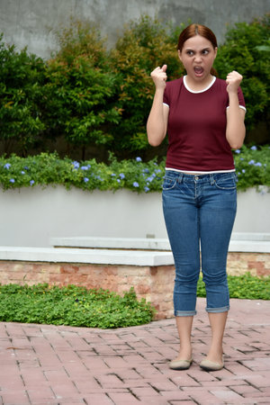 Pretty Female And Anger Wearing Jeans At Parkの写真素材