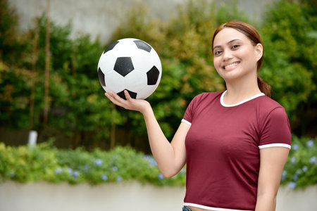 Youthful Redhead Female Smiling With A Ball At Parkの写真素材