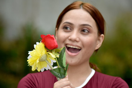 Happy Attractive Filipina Person With Flowers Standingの写真素材