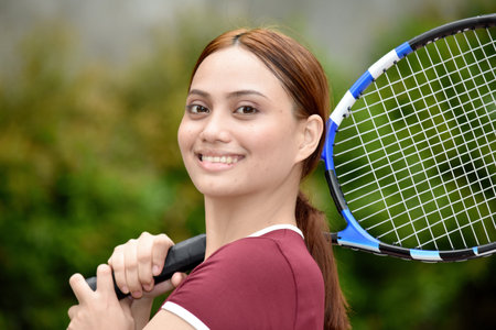 Smiling Beautiful Redhead Female With Tennis Racket Outsideの写真素材