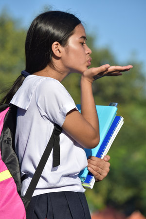 Girl Student Blowing A Kiss Wearing Uniformの写真素材