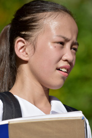 Portrait Of A Youthful Asian Person With Booksの写真素材
